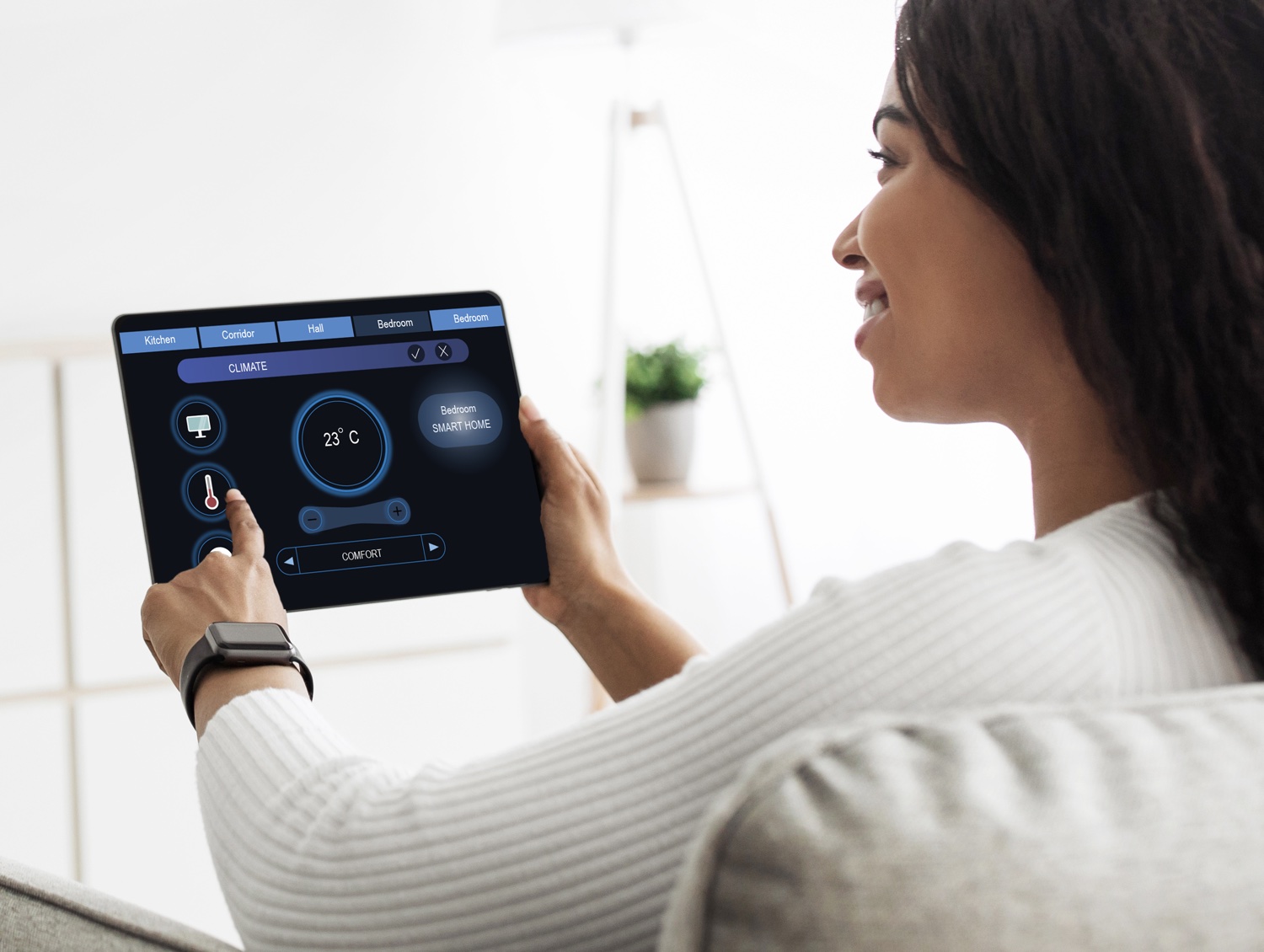 woman smiling at a tablet running smart home app